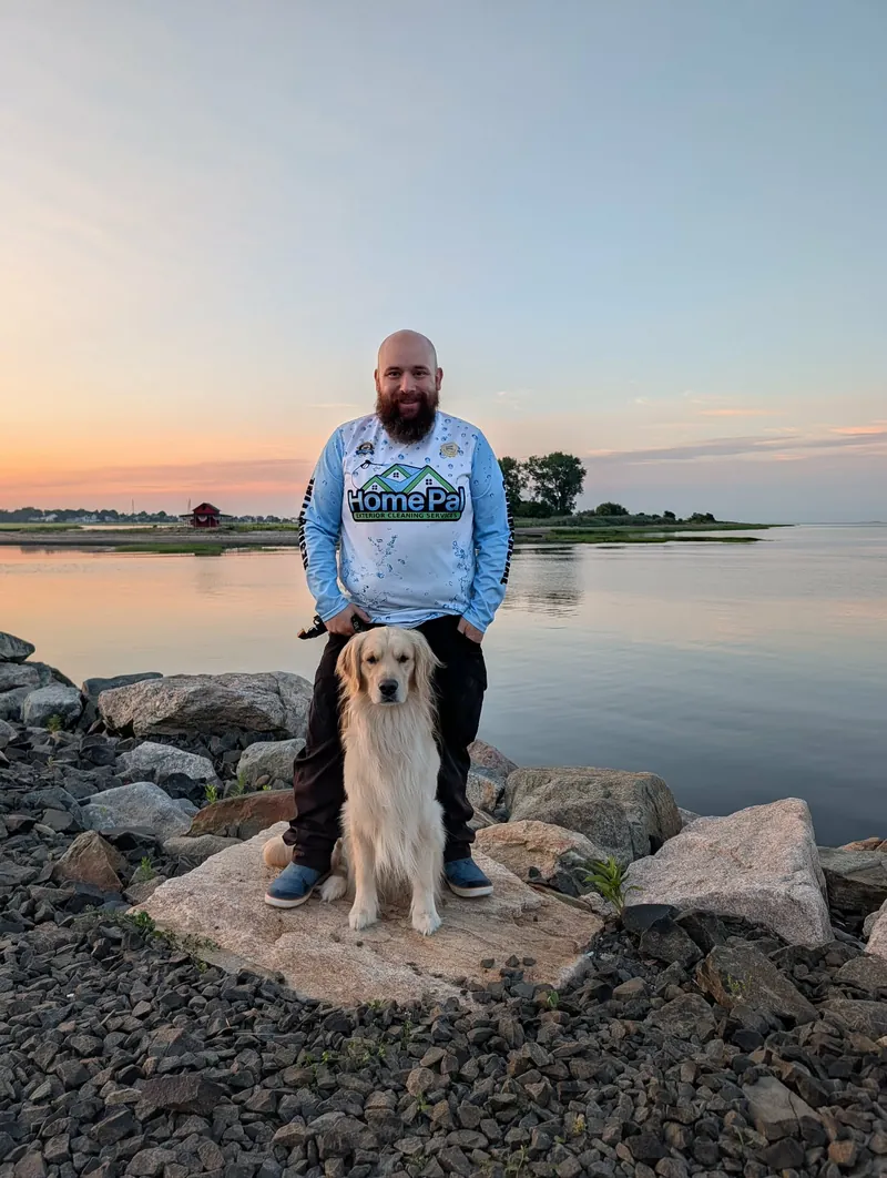 Greg Hicks, owner of HomePal Pressure Washing, with his dog by the water