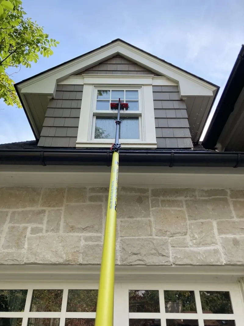 Water-fed pole reaching an upper-story exterior window from below